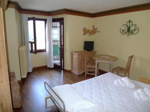 um quarto com uma cama branca, uma mesa e cadeiras em RTA Hotel Catturani em Madonna di Campiglio