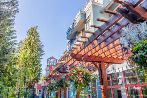 a building with a wooden pergola with flowers on it at Alpenglow Lodge by Elevate Vacations in Whistler +112 photos