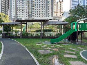 un parque infantil con un tobogán verde en Bunked Bed Room Sharing, en Manila
