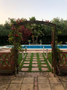 einen Garten mit einer Laube und einem Pool in der Unterkunft Casa Rural El Laure in Villamartín