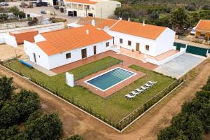 una vista aérea de una casa con piscina en Villa para 10 em Porches com piscina aquecida e ar condicionado, en Porches