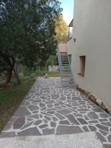 a stone walkway next to a building with a staircase at DILETTA M in Cala Liberotto