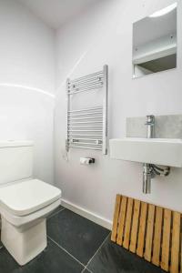 a white bathroom with a toilet and a sink at The Lodge in the heart of Boscastle. in Boscastle
