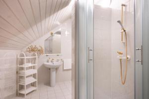 a white bathroom with a sink and a shower at Apartments Ladka in Begunje na Gorenjskem