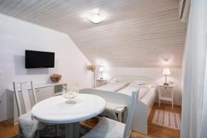 Camera bianca con tavolo e letto di Apartments Ladka a Begunje na Gorenjskem