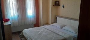 a bedroom with a white bed with a window at ARTEMIS HOME in Pétra