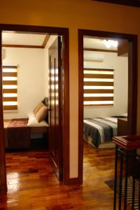 uma sala com um quarto com uma cama e um espelho em Eagle Ridge Family Vacation House em General Trias