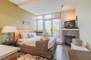 1 dormitorio con 1 cama y chimenea en Alpenglow Lodge by Elevate Vacations, en Whistler