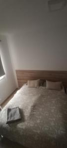 a bedroom with a bed with a book on it at Habitación privada Tenefe in Vecindario