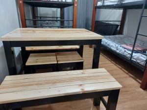a table and bench in a room with bunk beds at Male Room Sharing in Manila