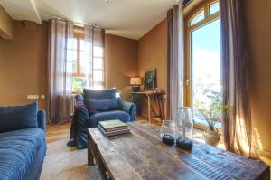 a living room with a blue couch and a wooden table at Erzgebirge Suite Altes Rathaus in Cranzahl