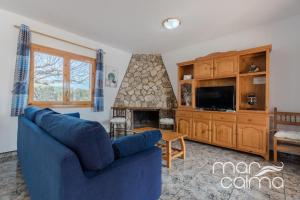 a living room with a blue couch and a fireplace at Villa La Roca by MarCalma in Les tres Cales