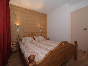 a bedroom with a bed with a wooden wall at Appartement Les Menuires, 2 pièces, 5 personnes - FR-1-344-856 in Les Menuires