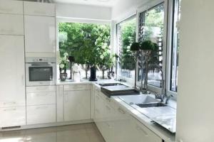 a kitchen with white cabinets and a large window at Ferienhaus am Lünner See in Lünne