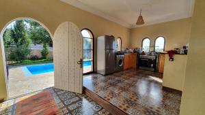 a kitchen with an open door leading to a pool at Belle villa Baldi à la campagne d'Essaouira in Essaouira