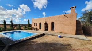 Belle villa Baldi à la campagne d'Essaouira في الصويرة: مبنى امامه مسبح