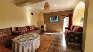 a living room with a couch and a table at Belle villa Baldi à la campagne d'Essaouira in Essaouira