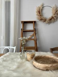 uma mesa com uma toalha de mesa branca e um vaso com flores em les chambres de pauline em Albertville