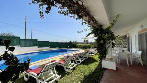 a swimming pool with lounge chairs next to a house at Espraguina - Private Pool - 16 Guests - Loulé in Loulé +34 photos