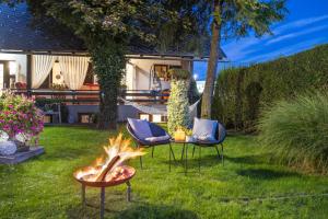 un cortile con due sedie e un focolare di Apartments Ladka a Begunje na Gorenjskem