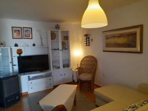 ein Wohnzimmer mit einem Sofa und einem TV in der Unterkunft Apartamento cerca del mar in Matalascañas