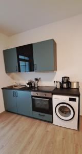 a kitchen with a stove and a washing machine at Waldstadt-Apartments in Iserlohn