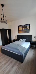 a bedroom with a large bed with a blue blanket at Waldstadt-Apartments in Iserlohn