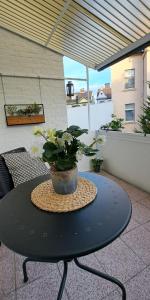 a black table with a potted plant on a balcony at Waldstadt-Apartments in Iserlohn
