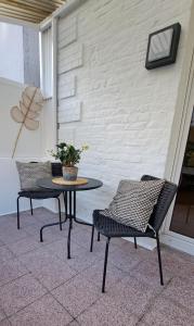 2 sillas y una mesa en el patio en Waldstadt-Apartments en Iserlohn
