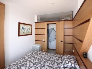 a small bedroom with a bed and a mirror at Sitges Views in Sitges