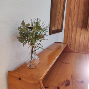 un jarrón con flores sentado en un estante de madera en Pensión Mesón La Lonja - Herbers, en Herbés