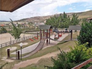 een speeltuin met een glijbaan in een park bij Flat Monte Castelo - Gravatá in Sairé