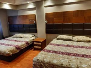 2 Betten in einem Schlafzimmer mit Holzböden in der Unterkunft mert apartman in Istanbul