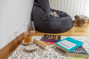 a table topped with a glass of beer and books at Rifugio Hemingway, Trieste centro con parcheggio in Trieste