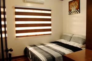 a bedroom with a bed and a window at Eagle Ridge Family Vacation House in General Trias