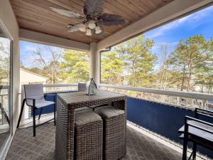 a screened porch with a table and a ceiling fan at Lake front Keowee Condo with Balcony & Resort Amenities! 20 min to Clemson condo in Salem