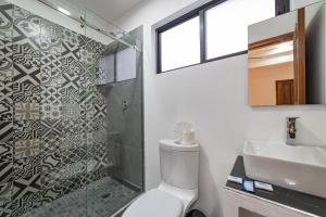 a bathroom with a shower and a toilet and a sink at Mi Querida Maribel Hotel in Santa Cruz Huatulco
