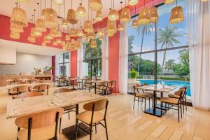 比亞埃爾莫薩的住宿－比亞埃爾莫薩森卡里嘉年華酒店，餐厅设有桌椅和大窗户。
