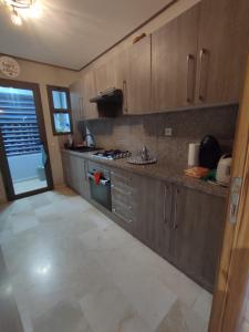 a kitchen with wooden cabinets and a counter top at LUXURY 3 bedroom apartment with pool, Nouaceur, Morocco in Derroua