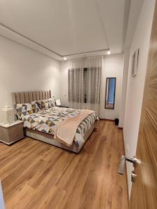 sypialnia z łóżkiem i drewnianą podłogą w obiekcie LUXURY 3 bedroom apartment with pool, Nouaceur, Morocco w mieście Derroua