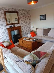 a living room with two couches and a table at Harlech/HUGE Three bedroom/BEST location in Llanbedr