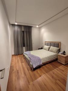 - une chambre avec un lit et du parquet dans l'établissement LUXURY 3 bedroom apartment with pool, Nouaceur, Morocco, à Derroua