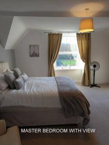 a bedroom with a large bed with a window at Harlech/HUGE Three bedroom/BEST location in Llanbedr