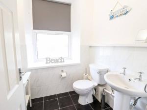 a white bathroom with a toilet and a sink at Harlech/HUGE Three bedroom/BEST location in Llanbedr