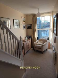 a living room with a stair case and a chair at Harlech/HUGE Three bedroom/BEST location in Llanbedr