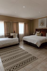 a bedroom with two beds and a rug at Marjaniek Wedding Venue & Guest House in Rietfontein