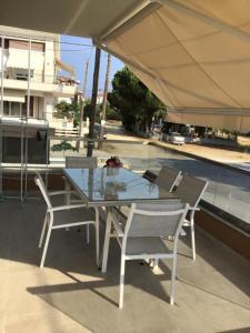 a table and chairs under an umbrella on a patio at Estia House M in Nikiti
