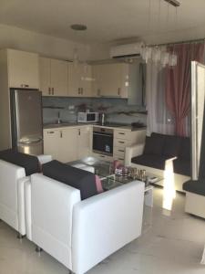 a living room with white couches and a kitchen at Estia House M in Nikiti