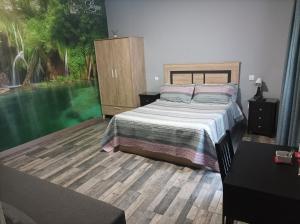 Un dormitorio con una cama y una ventana grande. en Hostal El Bosque Encantado Toledo, en Toledo