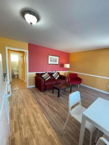 a living room with a couch and a red wall at Fair Isle Motel in Charlottetown